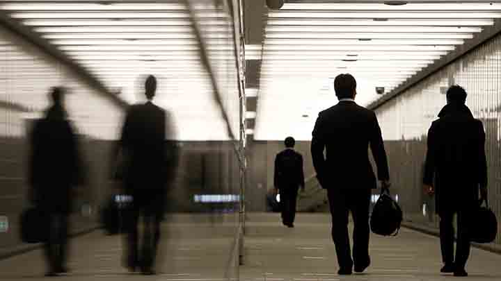 Businessmen walk through a business complex in Tokyo January 11, 2011.