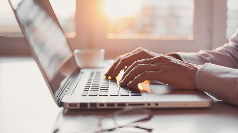 Hands typing in a laptop