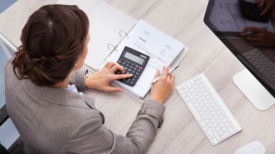 woman using calculator while working at desk