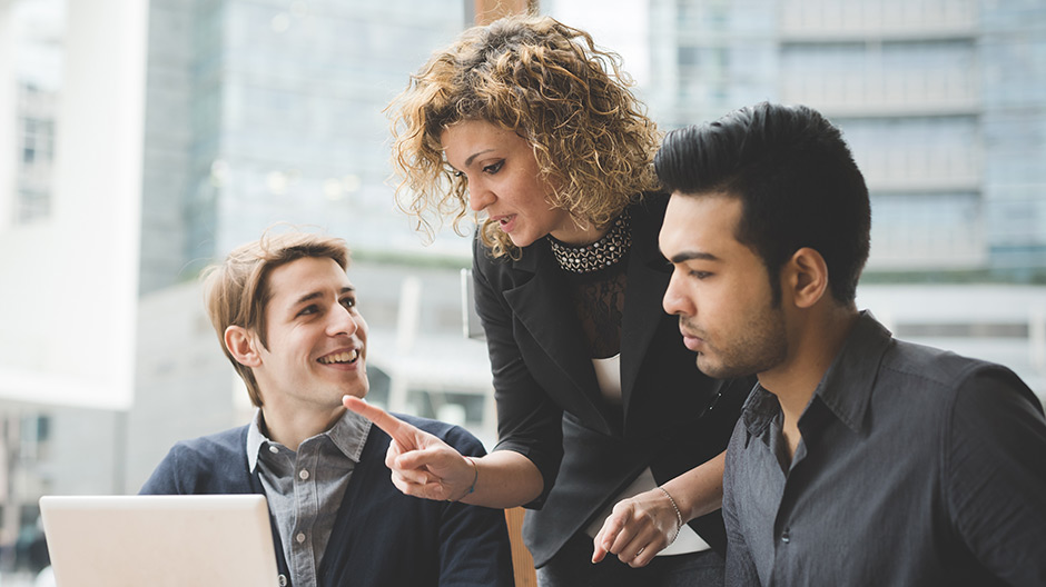 Three office workers discussing a work topic