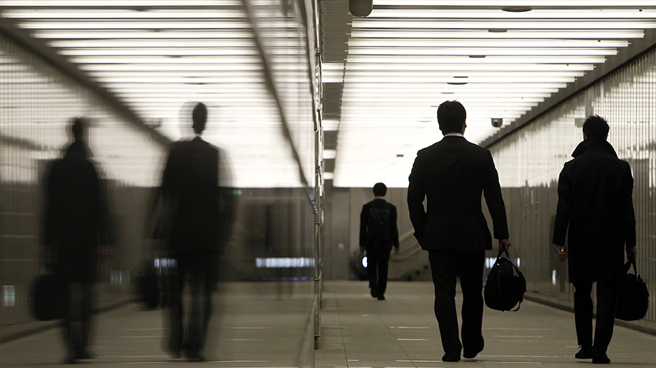 Businessmen walk through a business complex in Tokyo January 11, 2011